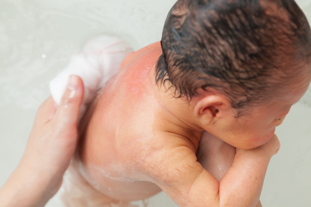 背中を洗われる赤ちゃん