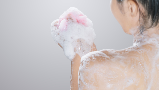 woman taking a shower with soap.skin health