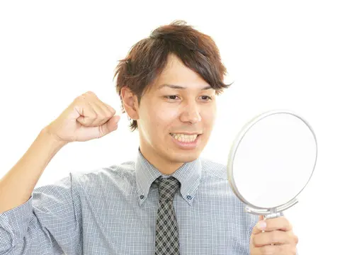 メンズパーマ 手鏡を持つ笑顔の男性